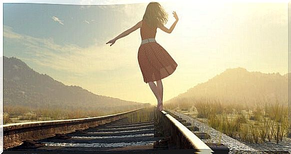 Woman walking on railroad tracks