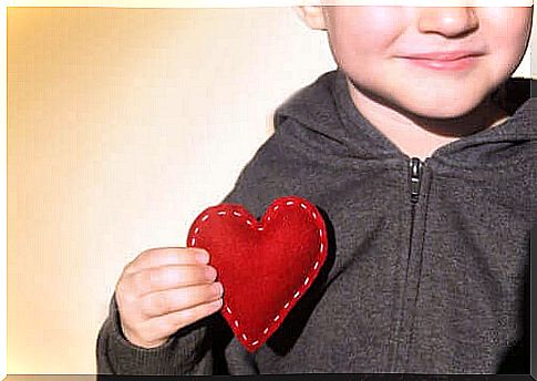 A child holds a heart with his hand