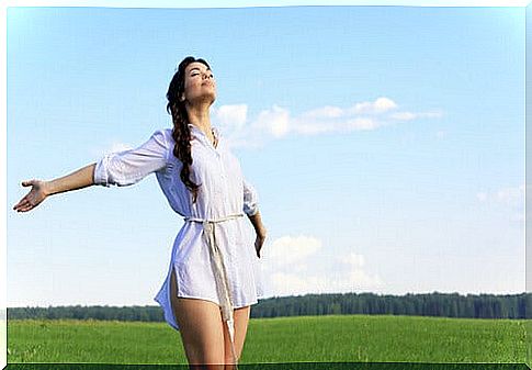 Mujer-con-los-brazos-abiertos-vestida-de-blanco-en-el-campo