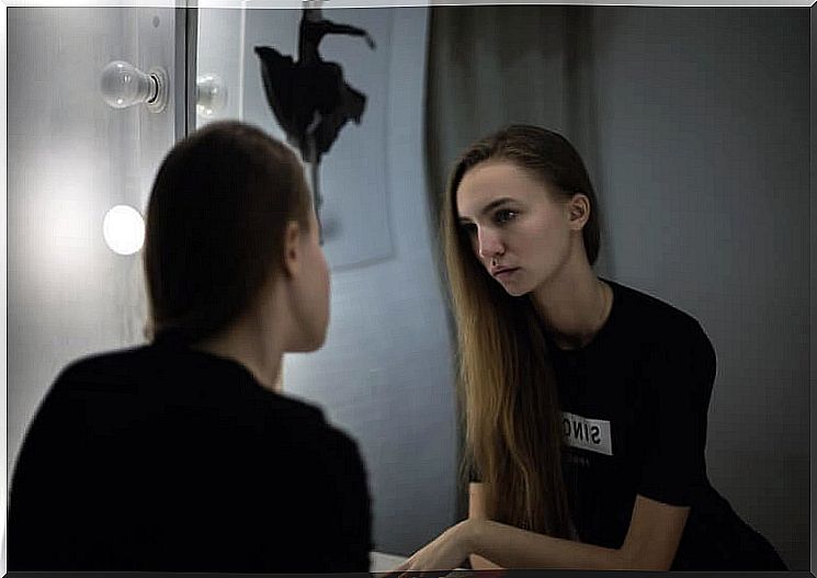 woman looking at herself in the mirror